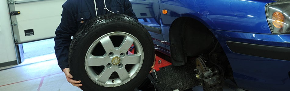 Car tyre being held by a student